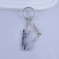 Detailed close-up of a resin cat keychain with a silver fishbone charm and metal ring - Pure White Cat Style