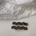 Close-up of wavy hair clips featuring black-and-white patterns and solid dark finish - Black White Spots / Dark Olive Green