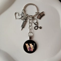 Detail of medical keychain featuring silver stethoscope syringe charms and floral letter W - Letter W