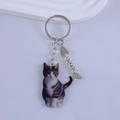 Close-up of realistic grey tabby cat resin keychain with a silver fish bone charm - Gray and White Tabby Cat Style