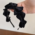 Detailed view of layered black velvet bows on a handmade headband with soft texture - Black