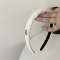 Detailed close-up of white tweed knitted headband with gold metallic button detail - Off White