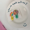 Close-up of rainbow and checkered hair clips on a white ceramic plate and display card - Half Round Rainbow & Colorful Grid Style (B-2800-3)