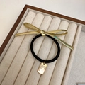 Eleganter schwarzer Haargummi mit goldenem Metallschleifen-Anhänger und Gravur - Goldenes Haargummi