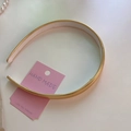 Dettaglio di un cerchietto oro opaco minimalista con etichetta fatta a mano e perle chic - Oro