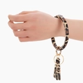 Detailed close-up of leopard print PU leather wristlet keychain with golden tassel ring - Beige Leopard