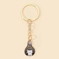 Close-up of a creative bulb-shaped keychain featuring a cute white cat and starry sky design - Starry Night Cat Lightbulb Style (8)