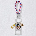 Close-up of metal bottle opener keychain with flag eagle charm and woven leather strap - Eagle and Flag Style