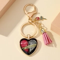 Gros plan du porte-clés mémorial en cœur avec pompon rose et texte commémoratif fille - En mémoire de la fille