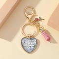 Makroaufnahme von Herz-Schlüsselanhänger in Gold mit rosa Quaste und kleiner Rose - Vogelzitat Gedenken (2)