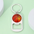 Detail of silver metal basketball keychain with integrated bottle opener and glossy finish - Basketball Texture Style