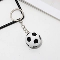 Classic black and white soccer ball keychain with silver metal ring on white background - Football