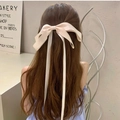 Elegant cream satin bow hair clip with long ribbons on dark brown wavy hair - Apricot