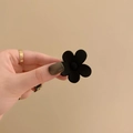 Matte black flower hair claw clip in medium size held by hand for scale display - 4cm / Black