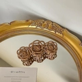 Braune hohle Rosen-Haarklammer in mattem Finish auf einer Vintage-Spiegelfläche - Brauner Rosenstil