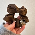 Detailed view of a brown satin hair scrunchie featuring sparkling crystal rhinestones - Brown