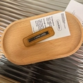 Detail einer quadratischen Leder-Haarklammer mit ingwergelbem Stoff auf Holztablett - Khaki