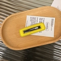 Detail of yellow rectangular leather hair clip showing the fine stitching and metal backing - Yellow