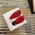 Pinzas para el pelo de cereza roja translúcida con hojas verdes sobre fondo de metal - Rojo