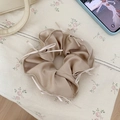 Detail of champagne gold satin scrunchie with silk ribbon bows on floral fabric - Champagne