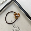 Détail d'élastique cheveux fleur en écaille de tortue avec perle et cordon marron - Écaille de tortue