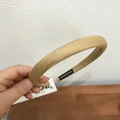 Detalle de una diadema ancha dorada con textura tejida y etiqueta de hecho a mano - Amarillo Jengibre