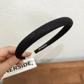 Detalle de la diadema de tela negra hecha a mano mostrando la etiqueta tejida interna - Negro