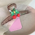 Detail of dark translucent shark hair clip with green bow and red cherry accents - Amber Cherry Style (D-4333-2)