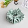Close-up of mint green satin scrunchie with delicate pearl accents on a white surface - Scrunchie / Blue