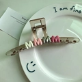 Pinza para el pelo con letras MMMM en degradado de colores sobre bandeja de cerámica blanca - Marrón