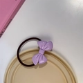 Détail d'un élastique à cheveux nœud en acrylique violet sur un plateau de présentation - Chouchou Violet