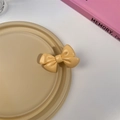 Vue détaillée d'une jolie pince à cheveux nœud orange crème sur un plateau blanc - Barrette Jaune