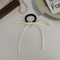 Close-up of elegant French style black hair tie with cream bow and pearl pendant detail - Beige