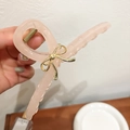 Pinza para el pelo rosa translúcida grande con un detalle de lazo dorado en la mano - Rosa