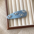 Blauwe denim haarclip met zilveren strikjes op een vintage sieradentrayset in hout - druppel / Blauw