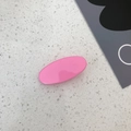 Detailed top view of a minimalist pink oval hair clip on a white terrazzo surface - Pink Purple