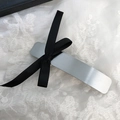 Dettaglio molletta vintage in metallo spazzolato argento su pizzo bianco elegante - Stile Argento Minimalista (D-5317-2)