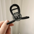 Primer plano de pinza para el pelo negra brillante con lazo plateado y dientes de muelle - Gris
