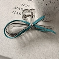 Détail d'une pince à cheveux argentée avec nœud en denim bleu et motif cœur ajouré - Pince Crabe Nœud Cœur Évidé Bleu Clair (D-5339-5) / Pince Crabe Nœud Cœur Bleu Clair