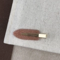 Close-up of glitter finish on bronze side hair clip placed on textured linen fabric - Orange (D-5345-7)