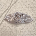 Detail van de elegante champagne satijnen roos haarklem met verfijnde bloemblaadjes - Champagne