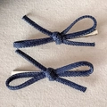 Dettaglio ravvicinato di fermagli per capelli in denim blu scuro con fiocco e base metallica - Grande / Blu scuro