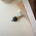 Dettaglio del fermaglio francese vintage con velluto blu e perle eleganti - Stile Quadrato Blu