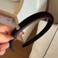 Detalle de una diadema de terciopelo negro grueso con una placa de logo redonda dorada - Estilo Negro (D-4512-2)