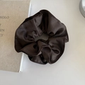 Solid deep coffee fabric scrunchie with pleated texture on a minimalist white surface - Brown