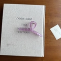 Purple acrylic spiral hair claw clip on a textured book cover with a rustic wood backdrop - Purple