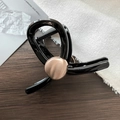 Close-up of black resin hair claw clip with rose gold metal detail on wood surface - Black With Gold Decoration (D-5182-3)