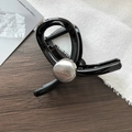 Detail view of a medium black hair claw clip with silver dome accent on a wooden surface - Black With Silver Decoration (D-5182-4)