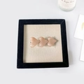Détail de trois barrettes à cheveux cœurs roses sur un présentoir élégant en tissu - Rose