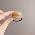High elasticity hair tie with amber ink wash acrylic arc detail held in hand - Amber